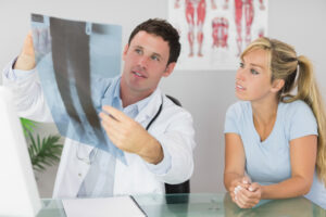 Content doctor showing a patient something on xray in bright office